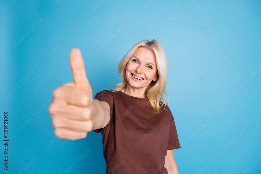 Fototapeta premium Photo of cheerful lovely nice woman wear stylish clothes demonstrate thumb up symbol isolated on blue color background
