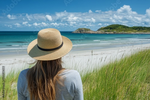 Woman wearing straw hat enjoys serene beach view with ocean waves under clear...