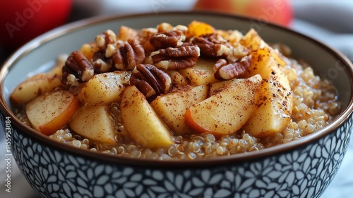 Warm apple and pecan quinoa bowl served with cinnamon and nutmeg for breakfas...