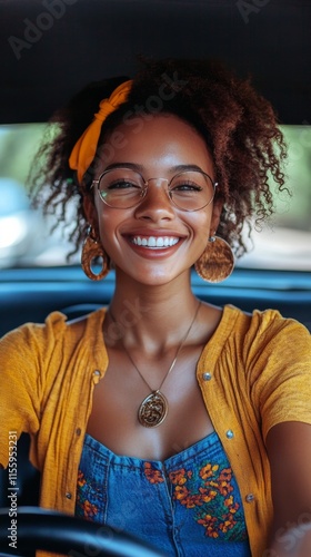 Smiling young woman with curly hair in a yellow tank top seated in a car duri...