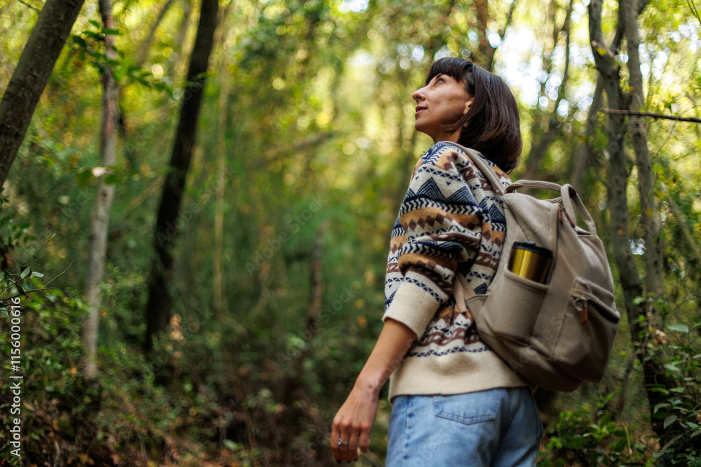 girl in a stylish sweater and with a backpack enjoys a walk in the forest. trekking in the forest. a girl with a backpack walks in the forest. trekking and hiking. girl in a stylish sweater and with a backpack enjoys a walk in the forest. trekking in the forest. a girl with a backpack walks in the forest. trekking and hiking.