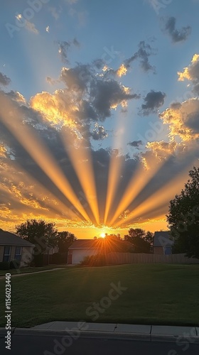 Beautiful sunset with rays of light shining through clouds in a quiet neighbo...