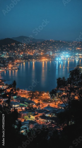 City lights sparkle over the calm bay at night with a vibrant skyline and mou...