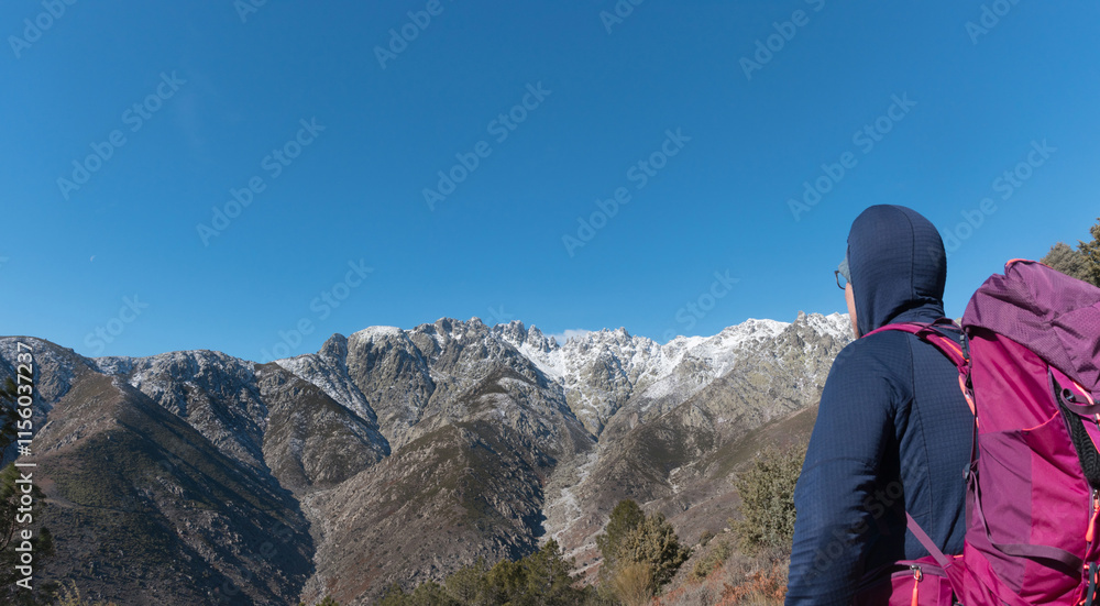 Mountaineer looking at the Sierra de Gredos with snow, southern part, travel ads and postcards, unusual views of the area.