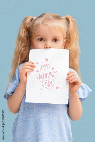 Cute little girl holding greeting card with text HAPPY VALENTINE'S DAY on blue background