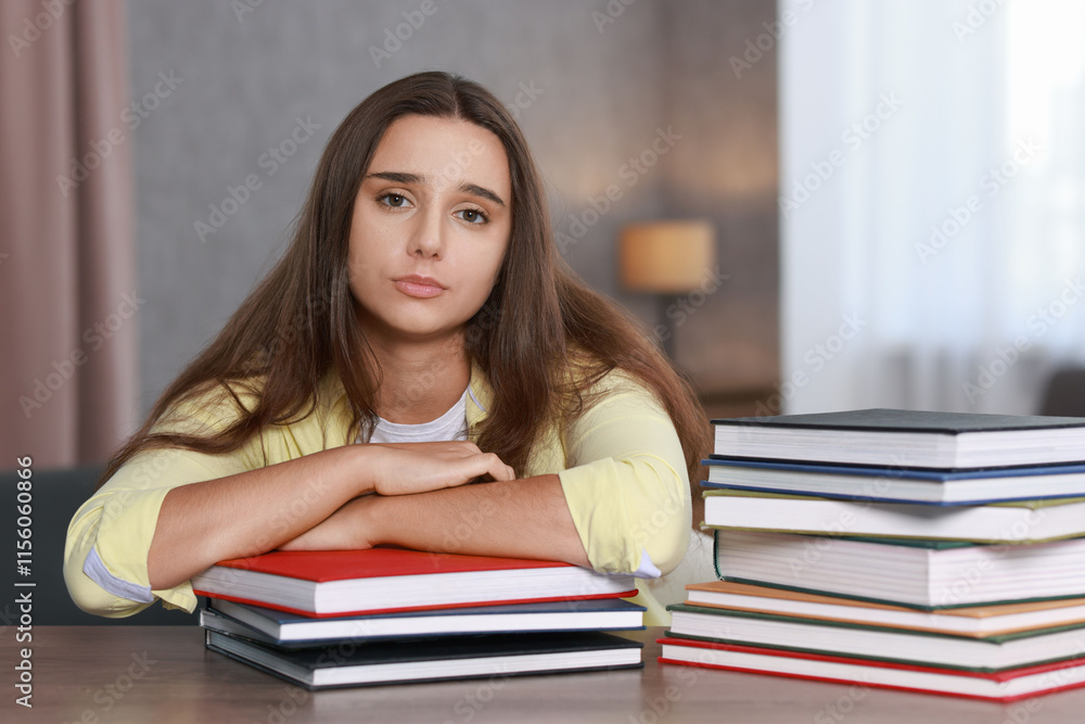 Young student with books having stress before exam at wooden table Young student with books having stress before exam at wooden table