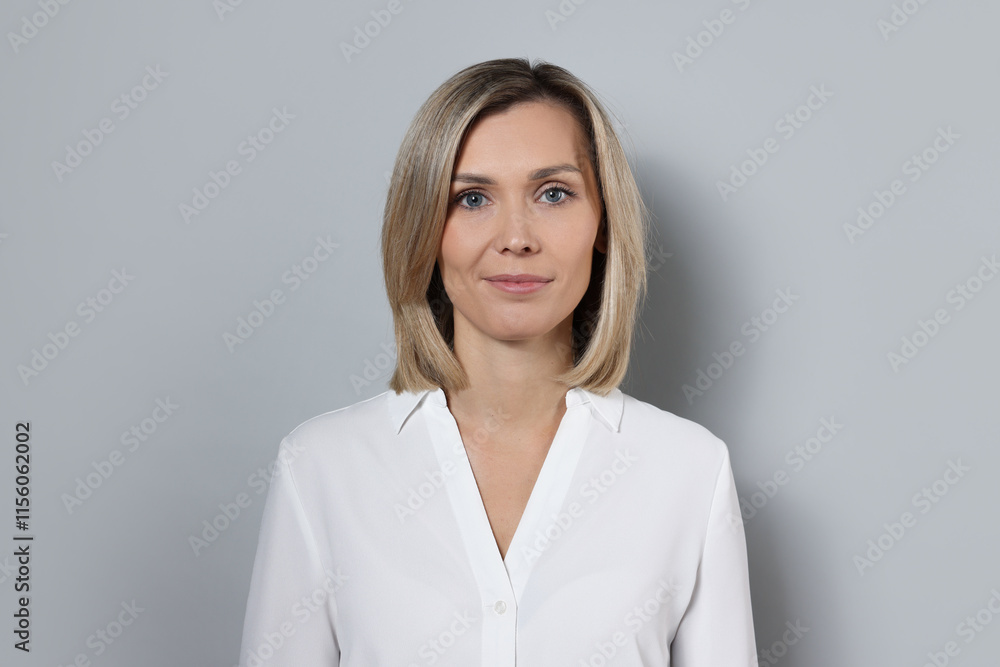 Portrait of businesswoman in white shirt on gray background Portrait of businesswoman in white shirt on gray background