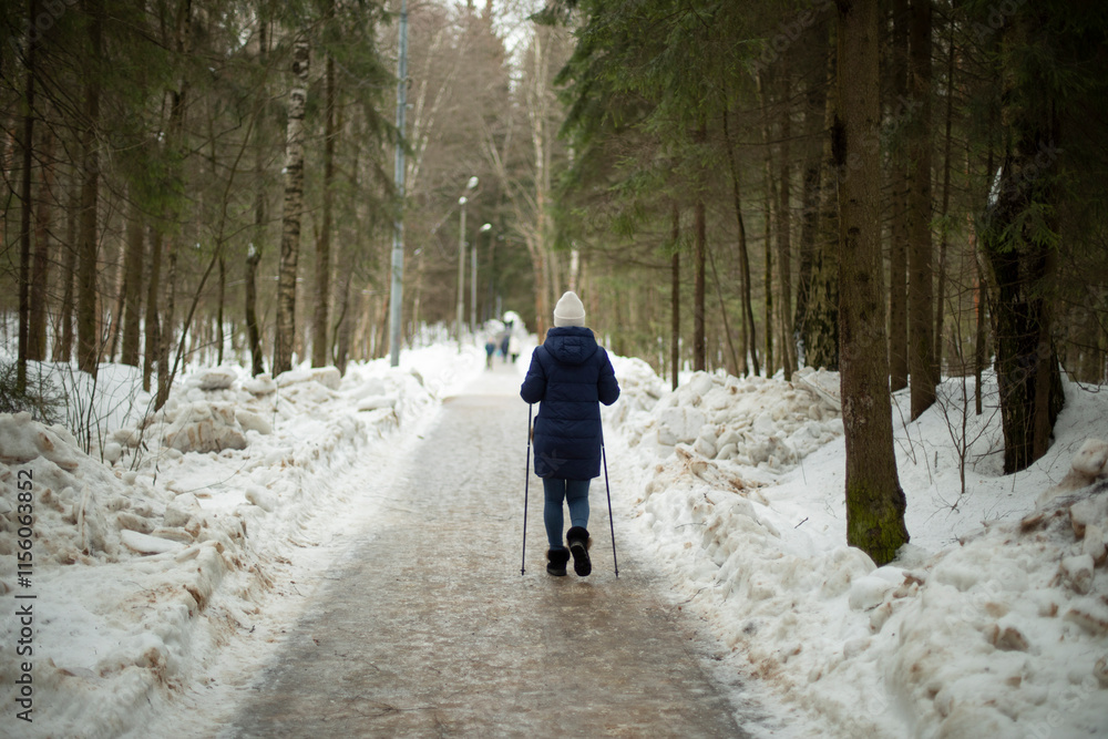 Woman with two ski poles in park. Useful walking in winter. Woman with two ski poles in park. Useful walking in winter.