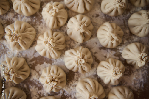 Homemade preparation of Georgian khinkali dumplings on a floured workspace photo