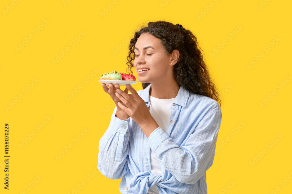 African-American woman with tasty eclairs on yellow background African-American woman with tasty eclairs on yellow background