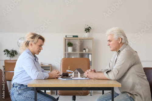Upset mature couple sitting...