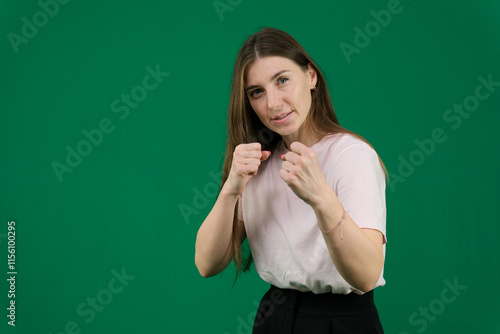 different emotions of a young girl on a green background chromakey beautiful facial features real people pink T-shirt white skinned European. black flared wide leg trousers photo