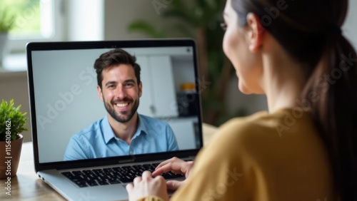 A woman is having a video chat on her laptop with a smiling man visible on the screen. Concept of: Remote connection.