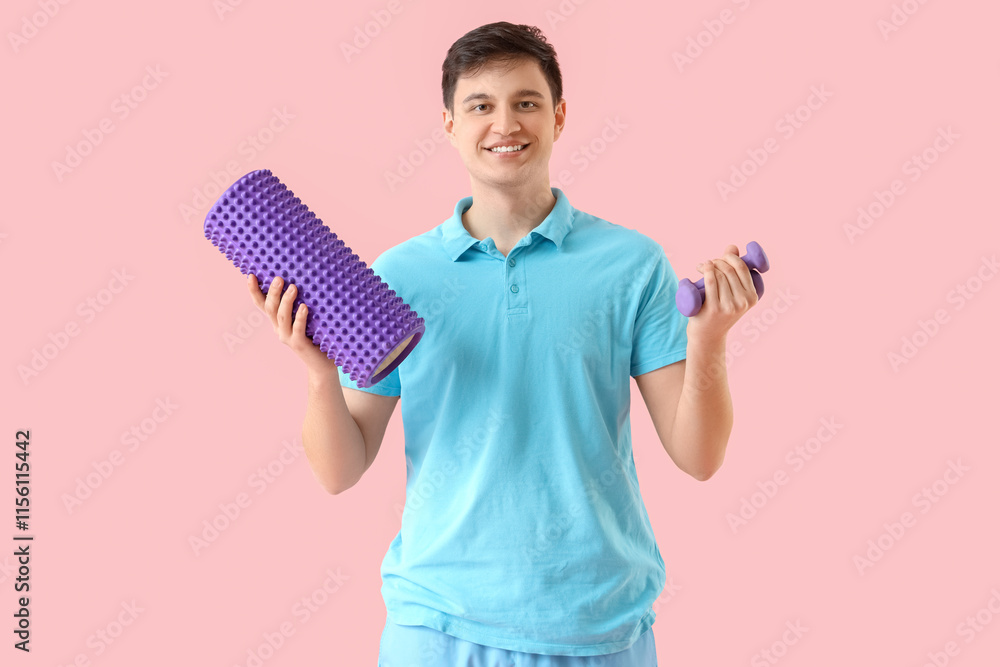 Male physiotherapist with foam roller and dumbbells on pink background Male physiotherapist with foam roller and dumbbells on pink background