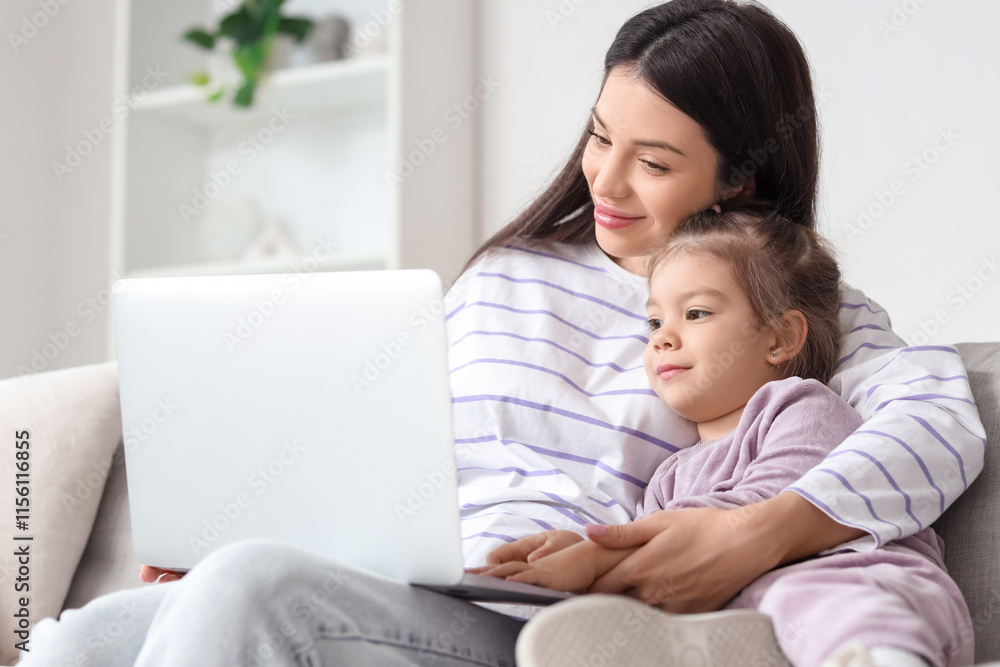 Young mother with her little daughter using laptop on sofa at home Young mother with her little daughter using laptop on sofa at home