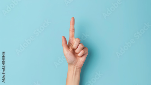 A female hand displaying four fingers, emphasizing with elegance against a serene light blue backdrop. photo