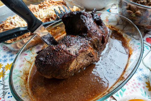 A joint of roast beef in a dish with gravy photo