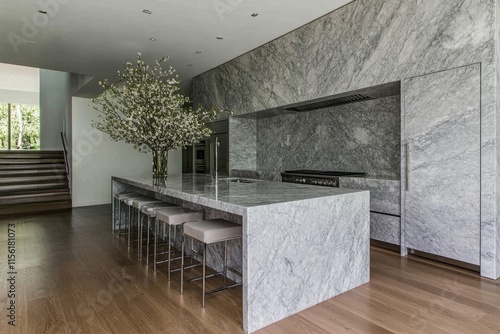 A modern kitchen with simple, sharp lines, minimalist stools, and muted gray tones accented by greenery photo