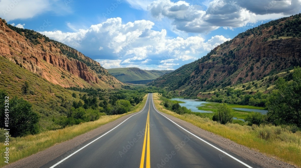 Naklejka premium An expansive road cutting through the Rockies, crystal-clear river running parallel