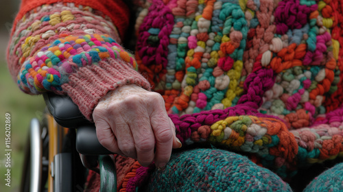 Elderly hand resting on wheelchair arm 