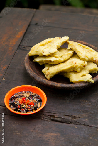 Фотография Tempe Mendoan, or Tempe Tepung, is thinly sliced tempeh coated in seasoned wheat flour batter and briefly fried to golden perfection