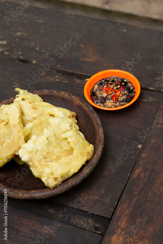 Фотография Tempe Mendoan, or Tempe Tepung, is thinly sliced tempeh coated in seasoned wheat flour batter and briefly fried to golden perfection