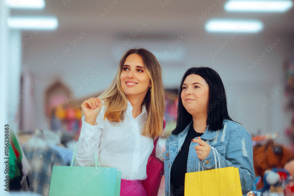Women Shopping Together in a Fashion Boutique. Cheerful girl on a shopping spree looking for new clothes 
