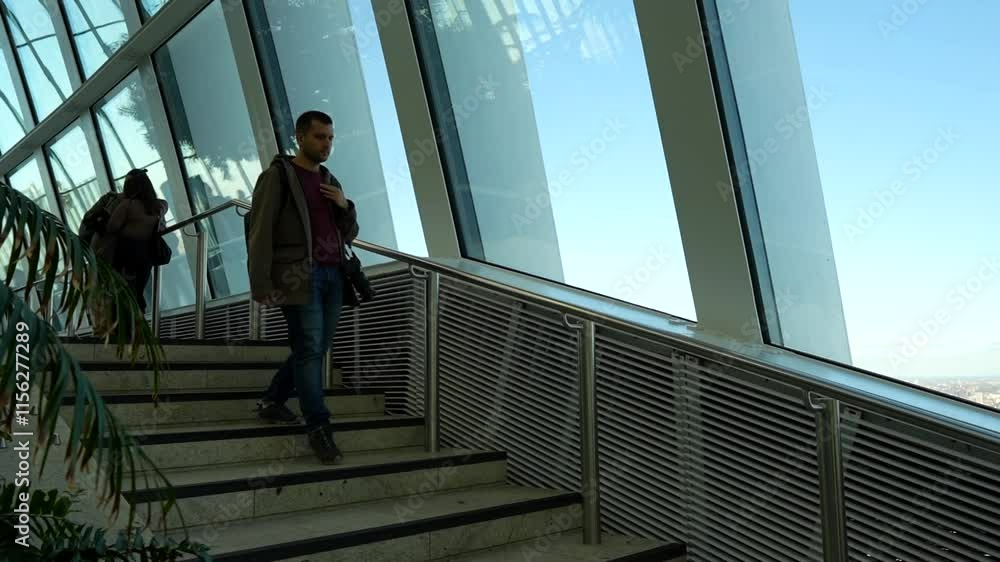 Tourist man walking down the stairs of a skyscraper in slow motion Tourist man walking down the stairs of a skyscraper in slow motion