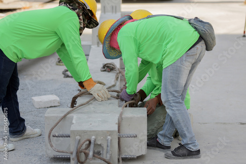 Wallpaper Mural Workers Collaborating to Secure Concrete Beam with Wire Rope Slings on Construction Site Torontodigital.ca