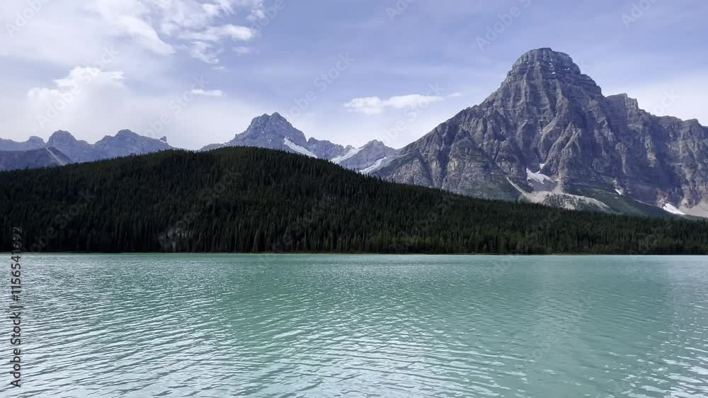 Turquoise water reflecting Crowfoot Mountain and surrounding peaks in Banff National Park in summer season, Zoom out