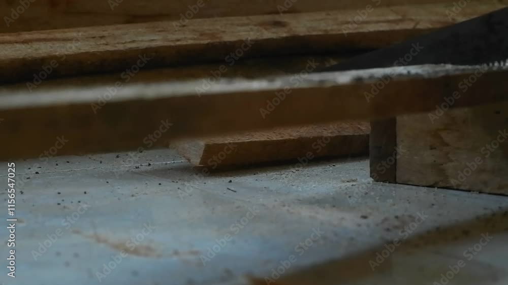Closeup of Craftsman Sawing Piece of Wood on the floor during the day Closeup of Craftsman Sawing Piece of Wood on the floor during the day