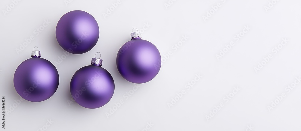 Fototapeta premium Elegant arrangement of purple Christmas ornaments on a clean white background emphasizing festive holiday spirit and decoration themes