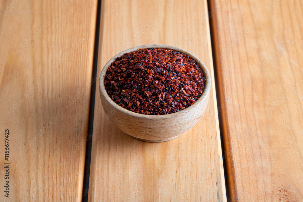 Red pepper flakes.Red chili peppers in wooden bowl on wooden table.Dried chili peppers Red pepper flakes.Red chili peppers in wooden bowl on wooden table.Dried chili peppers
