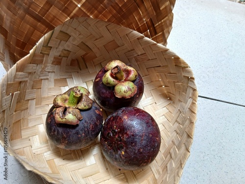 fresh mangosteen on wooden woven basket photo