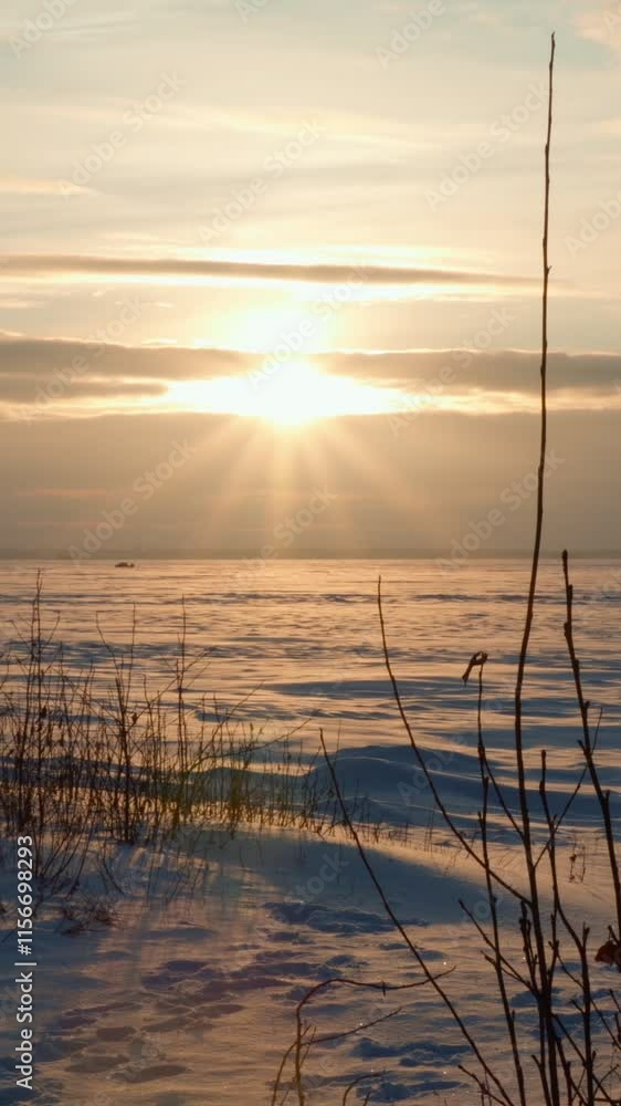 Winter sunset with a landscape view of a frozen freshwater lake. The silence and tranquility of winter nature. Vertical video, shorts. Winter sunset with a landscape view of a frozen freshwater lake. The silence and tranquility of winter nature. Vertical video, shorts.