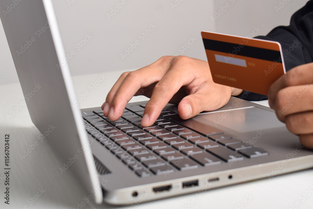 Hand holding credit card and using laptop. Businessman or entrepreneur working from home. Online shopping, e-commerce, internet banking, payment, spending money, work from home concept. Hand holding credit card and using laptop. Businessman or entrepreneur working from home. Online shopping, e-commerce, internet banking, payment, spending money, work from home concept.