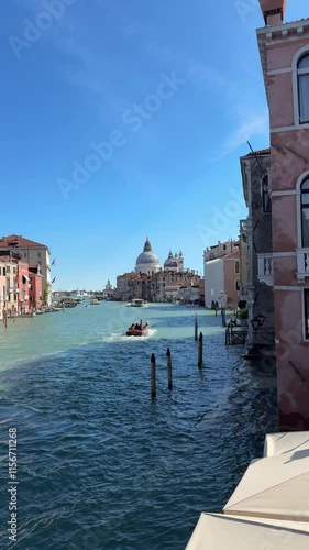 A boat crosses the streets of Venice, you can see a dome in the background
