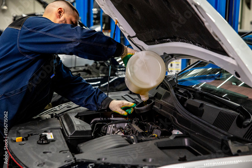 Man auto mechanic pouring mineral motor oil in car engine