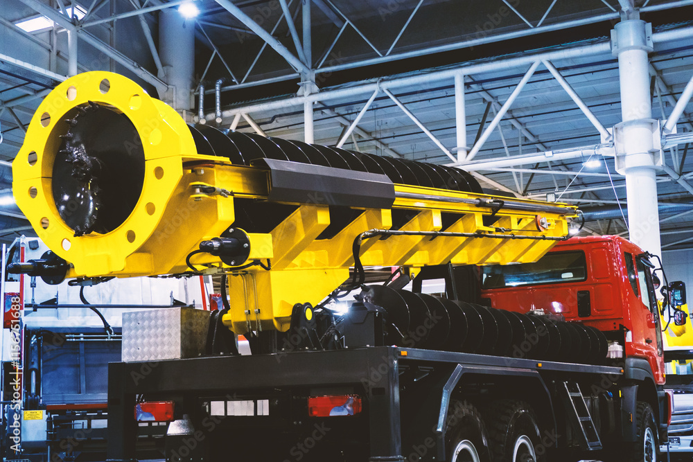 A drilling rig mounted on a truck, featuring a yellow boom and drilling mechanism. This equipment used for well drilling, geological exploration, or other geotechnical applications. A drilling rig mounted on a truck, featuring a yellow boom and drilling mechanism. This equipment used for well drilling, geological exploration, or other geotechnical applications.