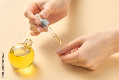 Women's hands apply oil with a pipette to care for the cuticle of nails