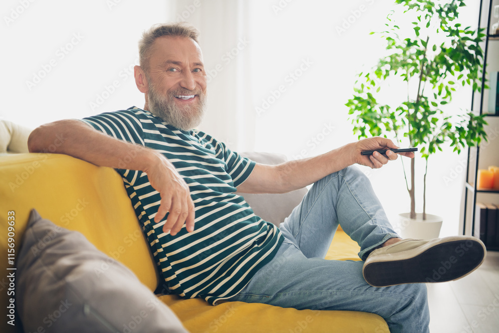 Fototapeta premium Happy senior man enjoying a relaxed day at home on a bright and cheerful weekend afternoon
