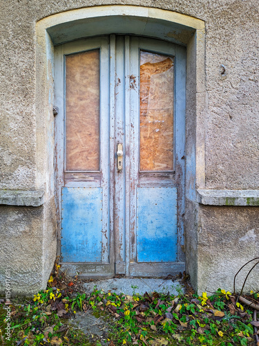 Arched wooden door of an old abandoned building entrance. photo