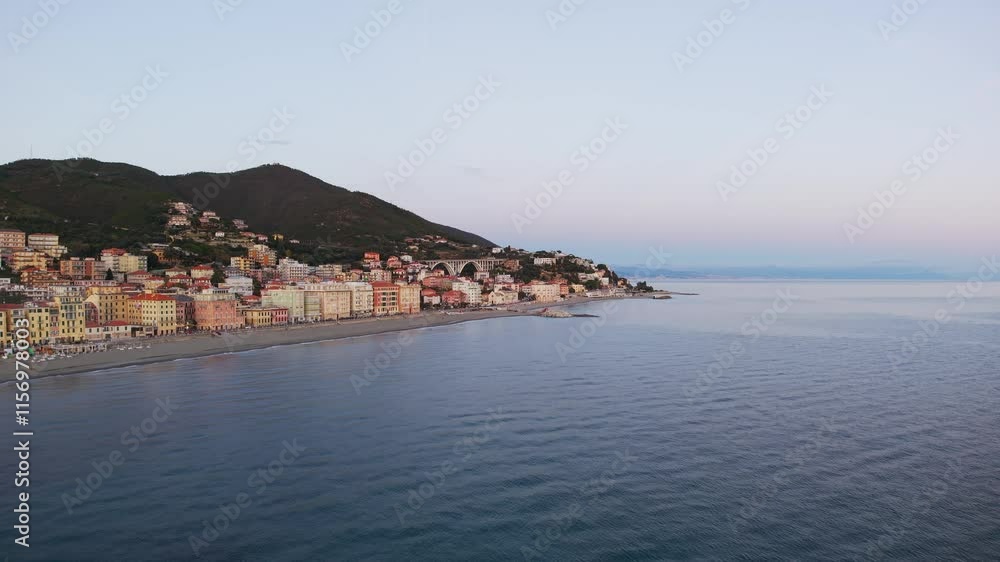 A serene aerial view of Varazze's coastline during sunset, featuring calm blue waters and picturesque hillside architecture, capturing the peaceful charm of this coastal town. A serene aerial view of Varazze's coastline during sunset, featuring calm blue waters and picturesque hillside architecture, capturing the peaceful charm of this coastal town.