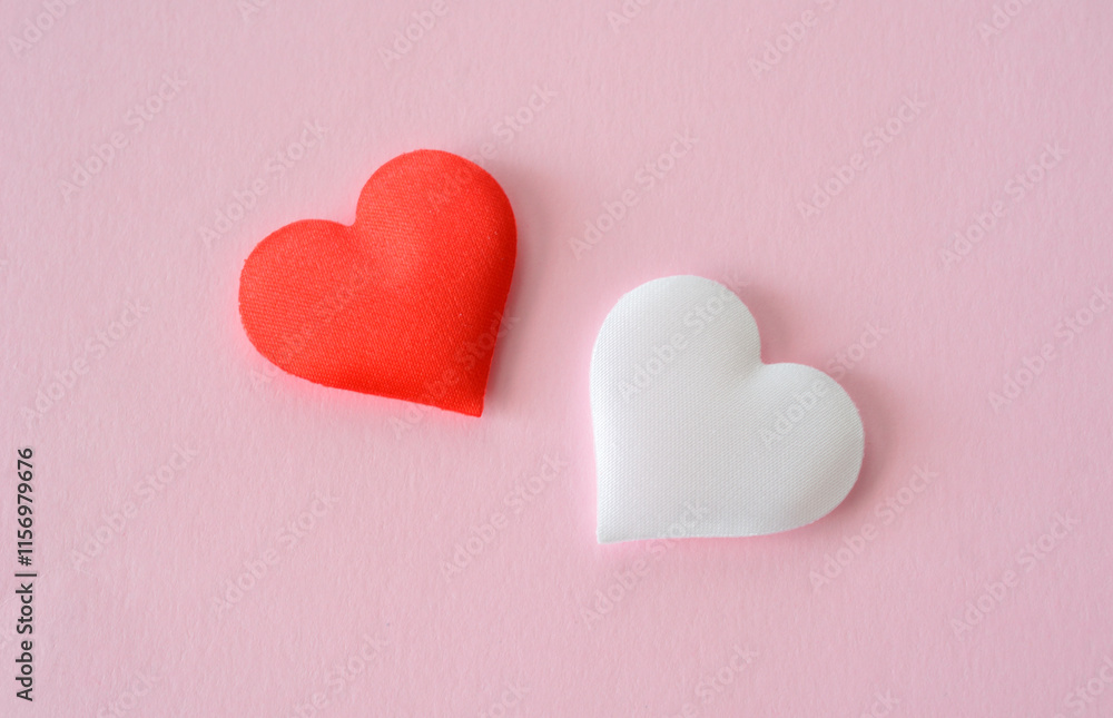 Obraz premium two red and white silk hearts isolated on the pink background macro
