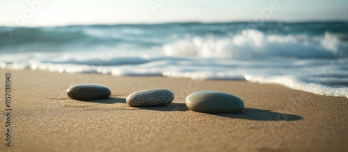 Tranquil beach scene featuring smooth stones on golden sand with gentle ocean waves in the background during a serene vacation setting
