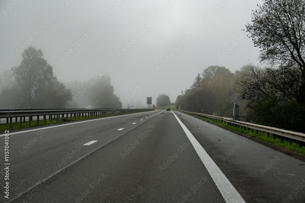 Driving by car on road in Belgium, fog in Ardennes ,nature park, Wallonia Driving by car on road in Belgium, fog in Ardennes ,nature park, Wallonia