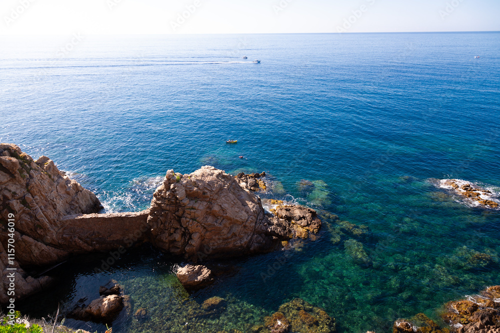 Beautiful turquoise mediterranean sea washing rocky coastline on sunny summer day
