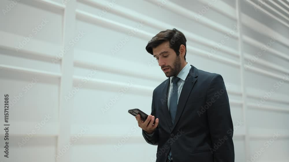 Skilled manager using phone call to contact colleague about project. Handsome male leader calling his business team to report and discuss about sales while standing and looking at camera. Exultant. Skilled manager using phone call to contact colleague about project. Handsome male leader calling his business team to report and discuss about sales while standing and looking at camera. Exultant.