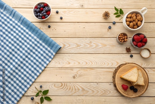 Top view of a light wooden table with a blue checkered tablecloth and space for text – ideal for food bloggers, recipe creators, or businesses in the culinary and hospitality industry.