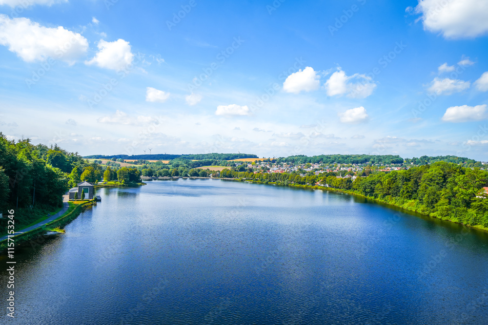 Fototapeta premium View from the historic dam wall at Möhnesee. Möhne Dam with the surrounding nature on the lake. 